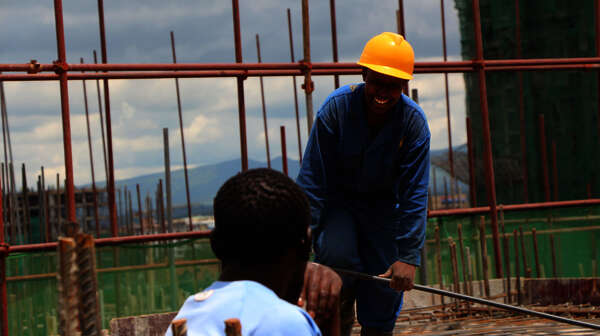 Zwei Männer im SkillUp!-Projekt sprechen auf einer Baustelle in Kenia miteinander.