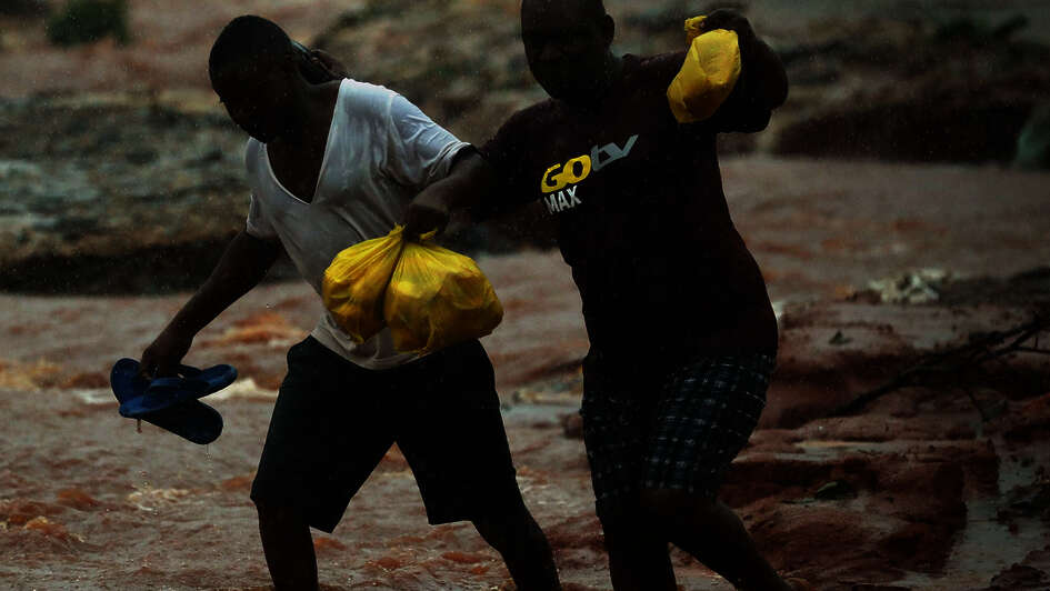 Two men walking through a flooded area