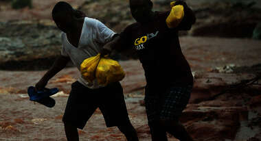 Two men walking through a flooded area
