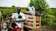 2021-agrishare-fischzucht-equipment-moped-uganda_C_welthungerhilfe.jpg Ein Bauer in Uganda auf einem Moped, 2021.