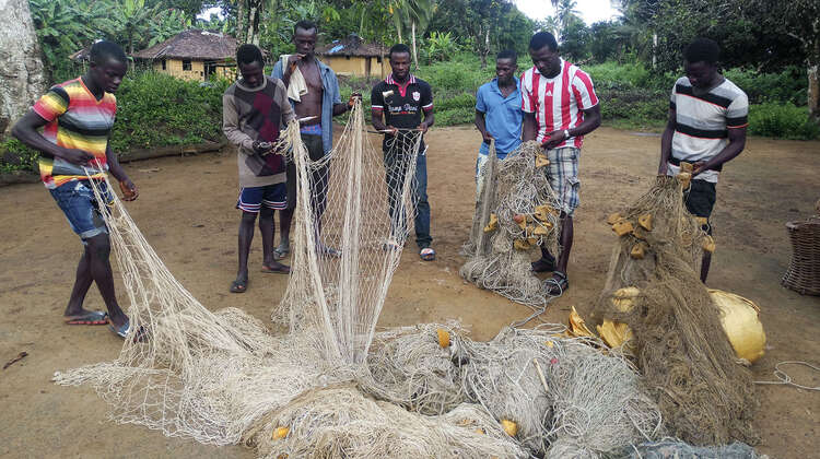 Eine Gruppe von Männern beim Sortieren von Fischernetzen