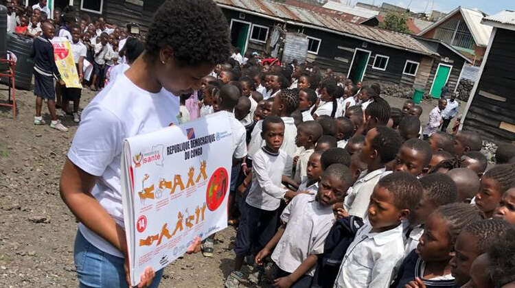Eine Frau zeigt Schulkindern in der Nähe von Goma (D. R. Kongo) zur Ebola-Prävention Bilder, wie sie sich gründlich die Hände waschen können. Eine Frau zeigt Schulkindern in der Nähe von Goma (D. R. Kongo) zur Ebola-Prävention Bilder, wie sie sich gründlich die Hände waschen können.