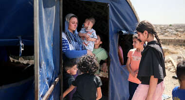 A mother and children stand outside a makeshift accommodation in Sinjar, Iraq.