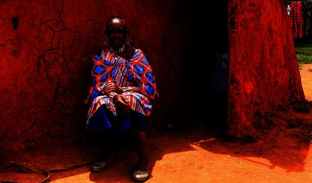 Massai Esther Sululi Makooi in front of cabin.