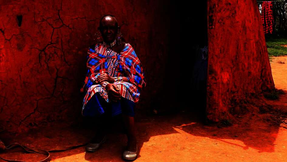 Massai Esther Sululi Makooi in front of cabin.