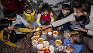 Eine Familie isst eine Mahlzeit der Suppenküche für Erdbebenopfer, Mardin/Türkei 2023.
