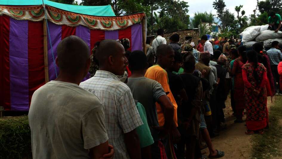 Men with shaved heads are standing in line