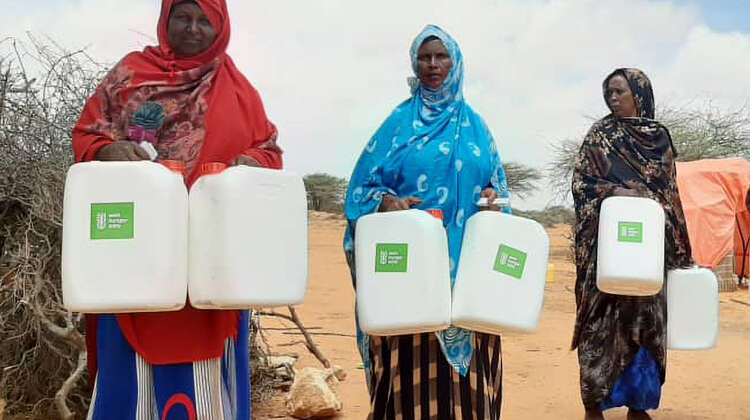2022-duerre-frauen-wasserbehaelter-somalia-c-welthungerhilfe.jpg Drei Frauen stehen nebeneinander, sie halten alle zwei Wasserbehälter mit Welthungerhilfe-Logo.